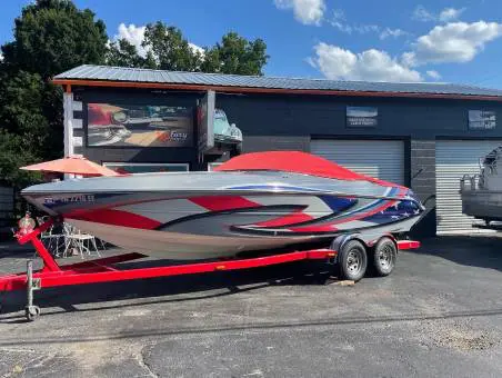A boat is parked in the driveway of a garage.